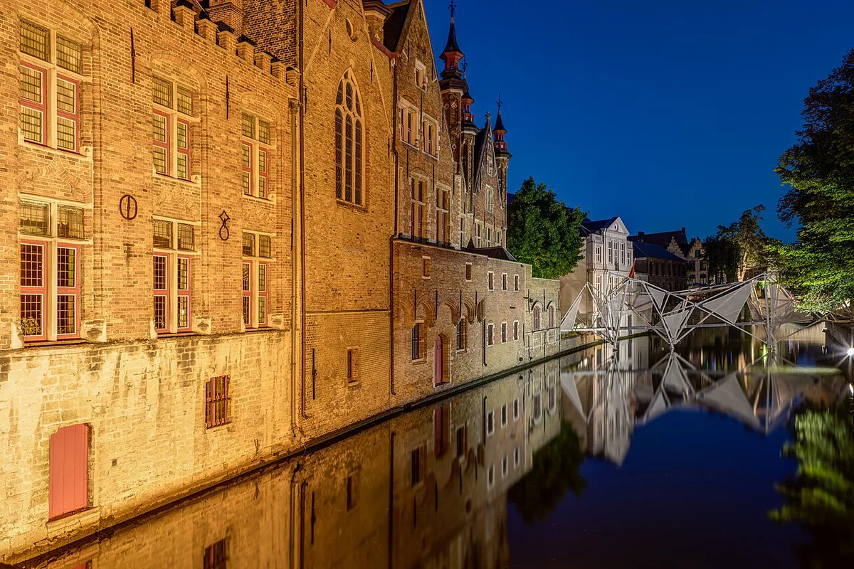 Historic canal houses reflected in the water in Ghent, a popular day trip from Brussels — 1