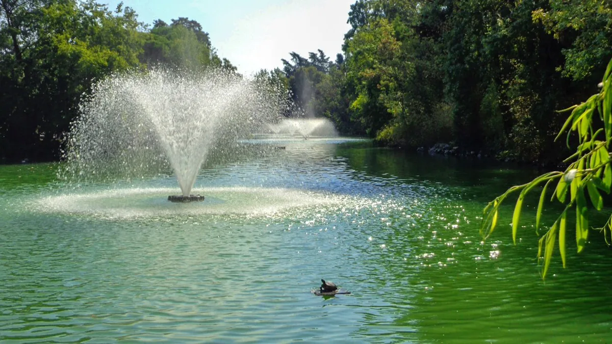 Locals relaxing on the lawns beside the lake at Giardini Margherita park in Bologna — 2
