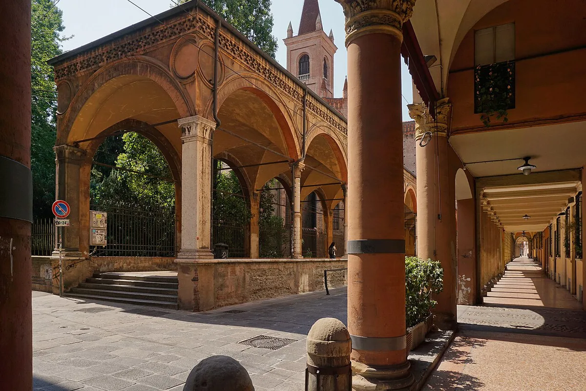 Porticoed street in Bologna's historic center with terracotta buildings under a covered walkway — 2