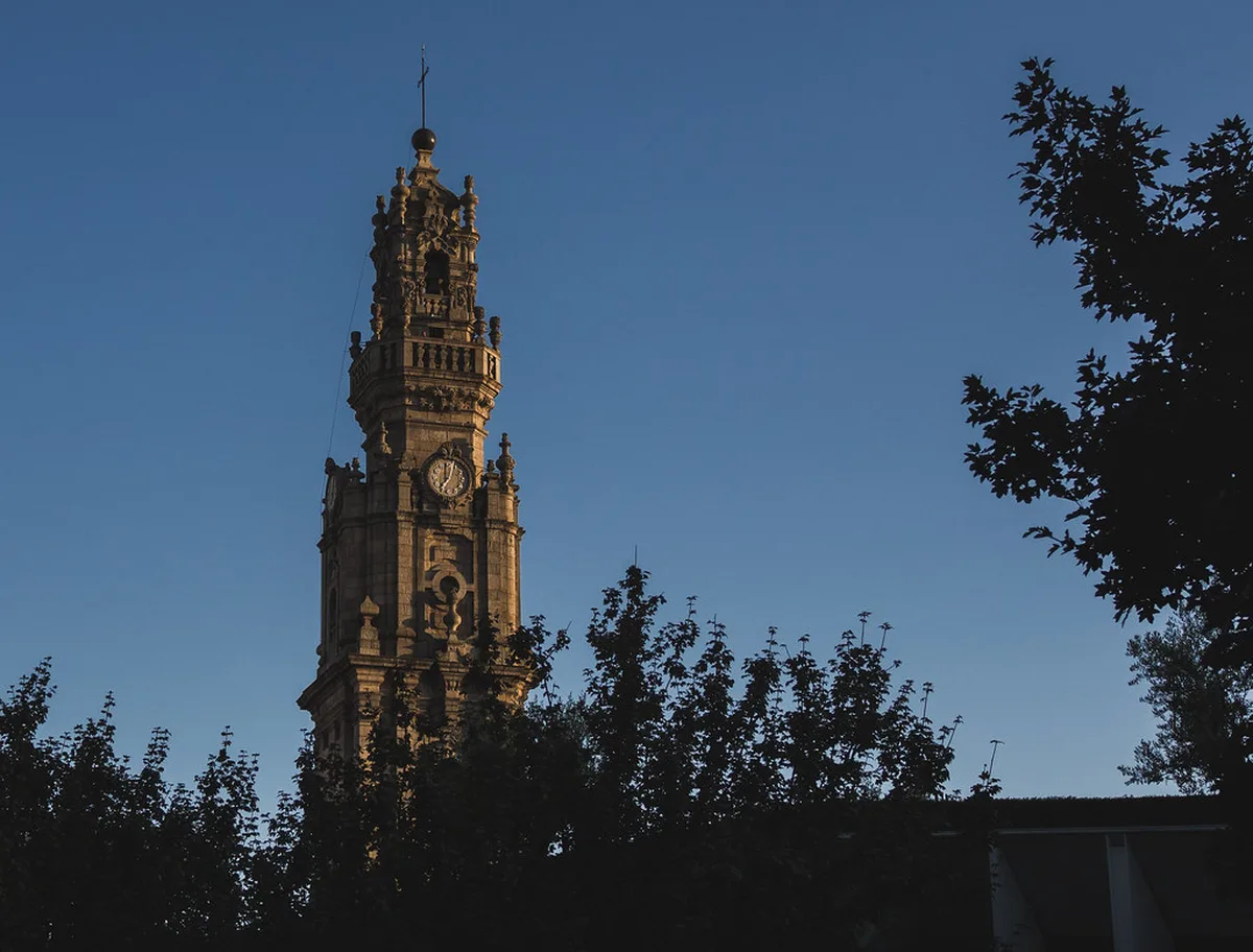 Clerigos Tower rising above Porto rooftops and historic buildings with the Douro River visible in the background