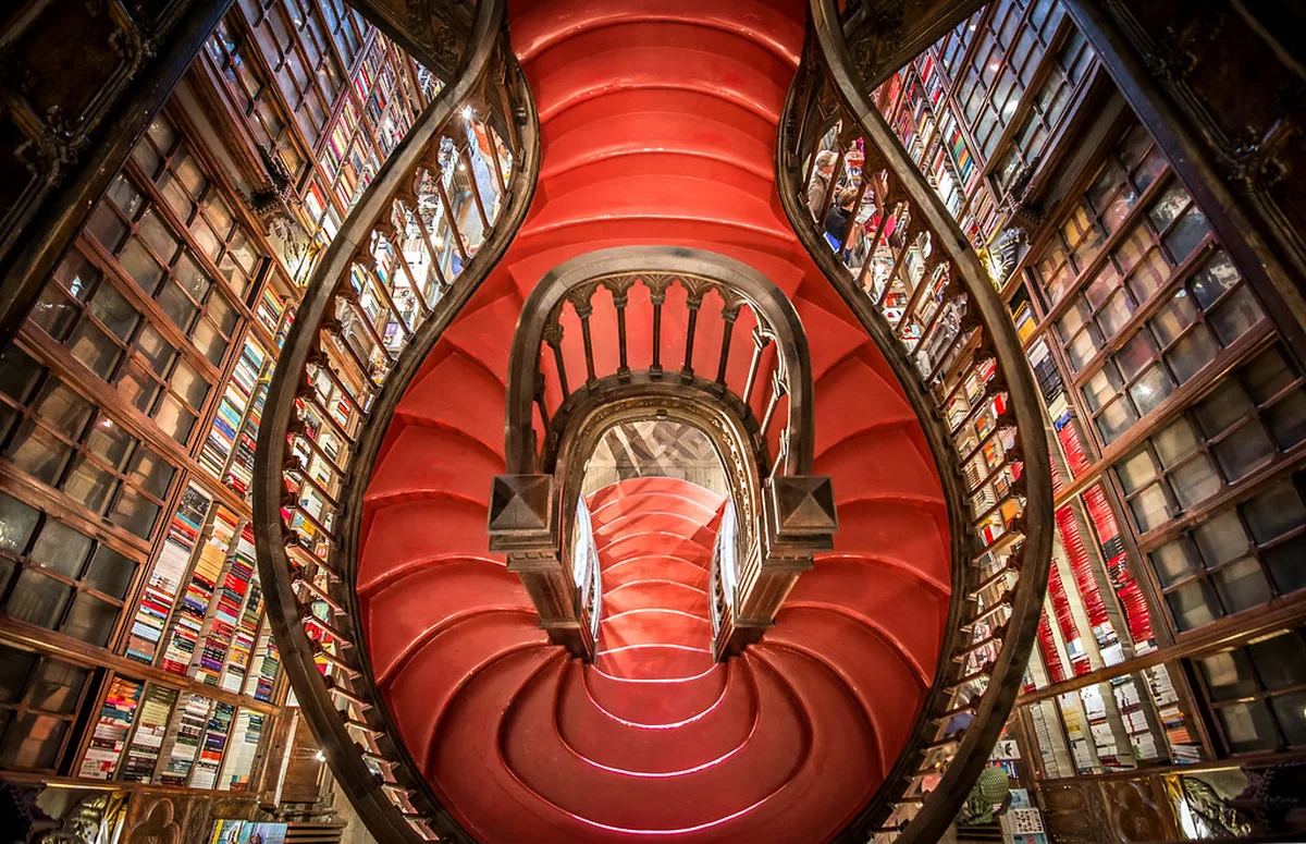Bright red spiral staircase at the center of Livraria Lello bookshop in Porto