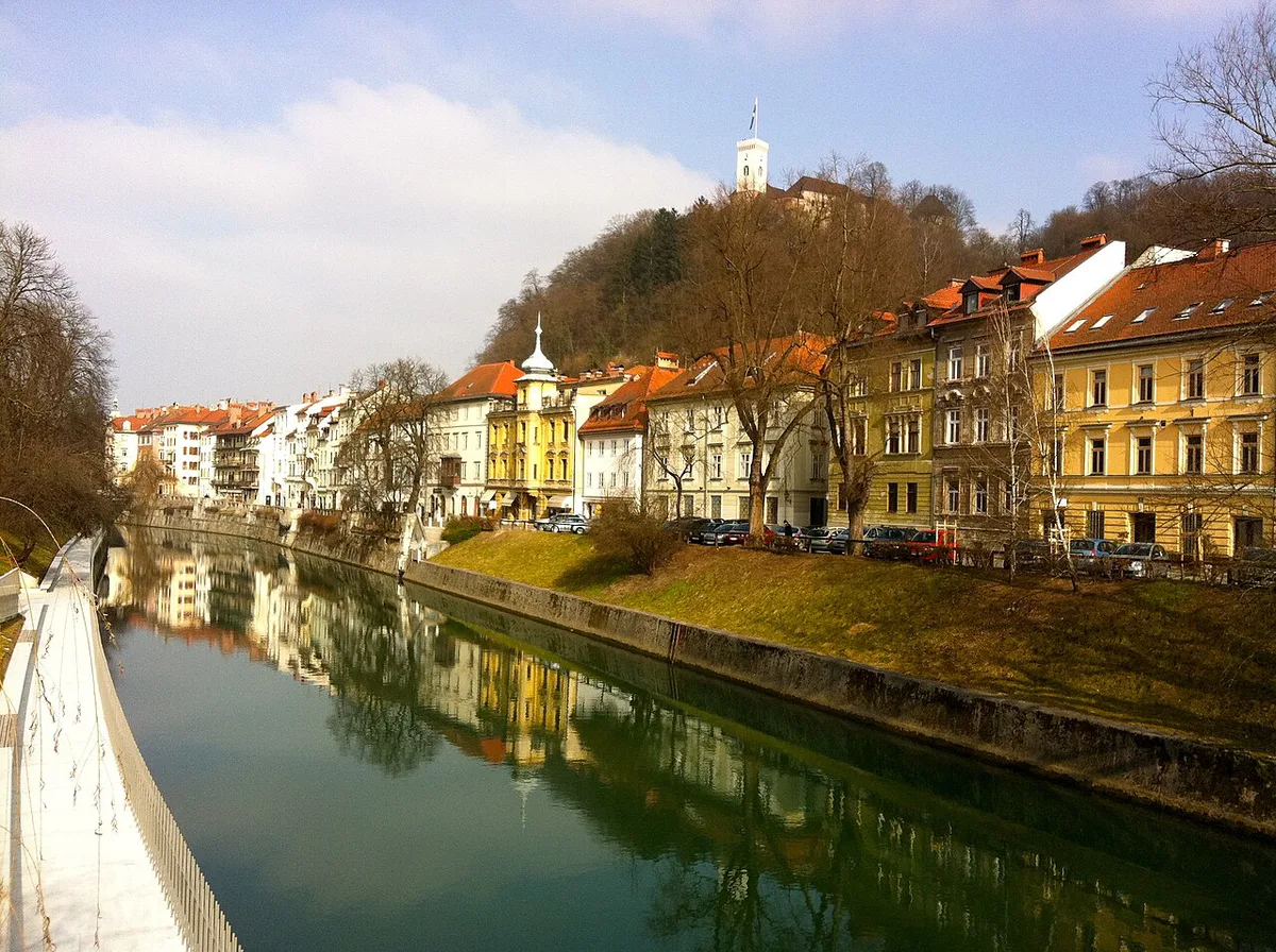 Old Town rooftops and Ljubljana Castle seen from across the Ljubljanica river — 1