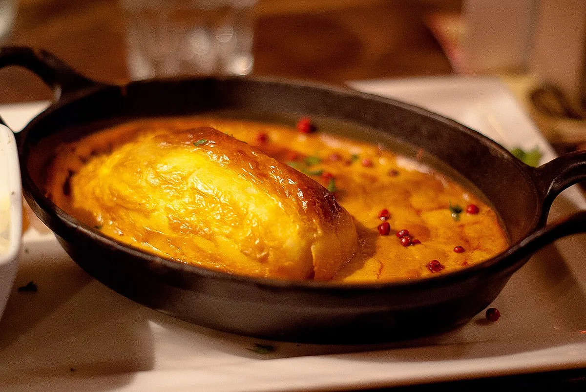 A pink praline tart alongside quenelle and cervelle de canut on a Lyon bouchon table — 1
