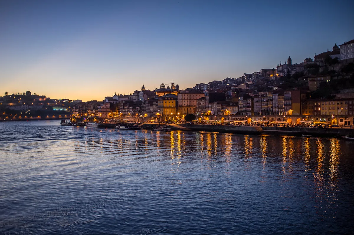 Golden hour sunset view over Porto Douro River waterfront with architecture and lights