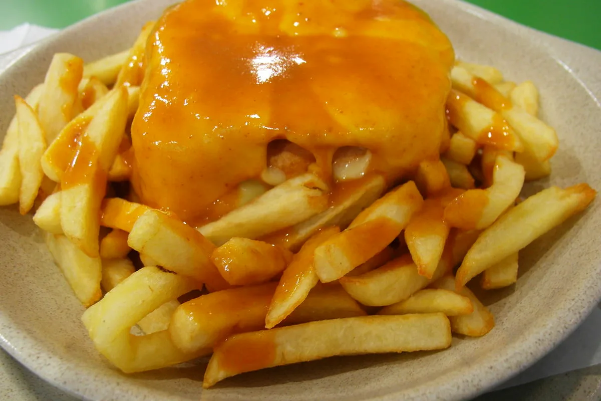 Francesinha sandwich with melted cheese and beer-tomato sauce served in Porto