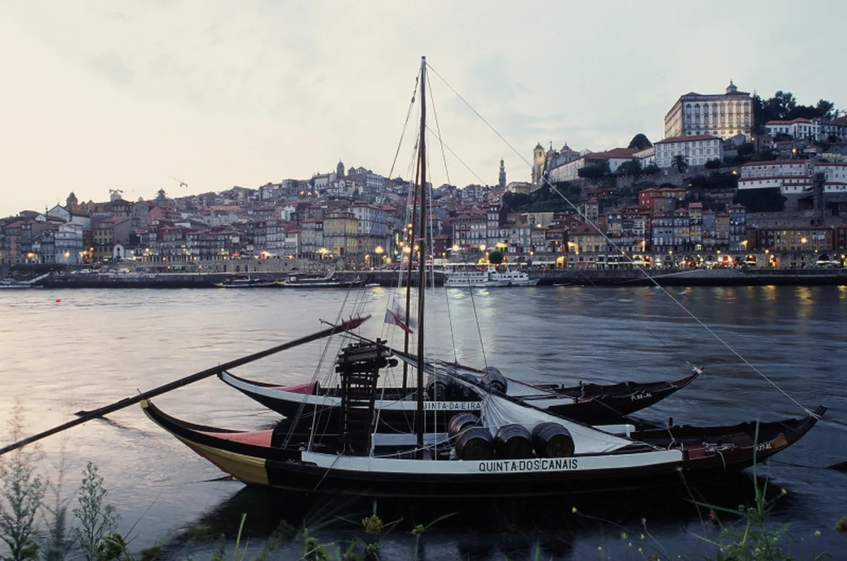 Colorful medieval houses in Ribeira Porto reflected in Douro River at dusk