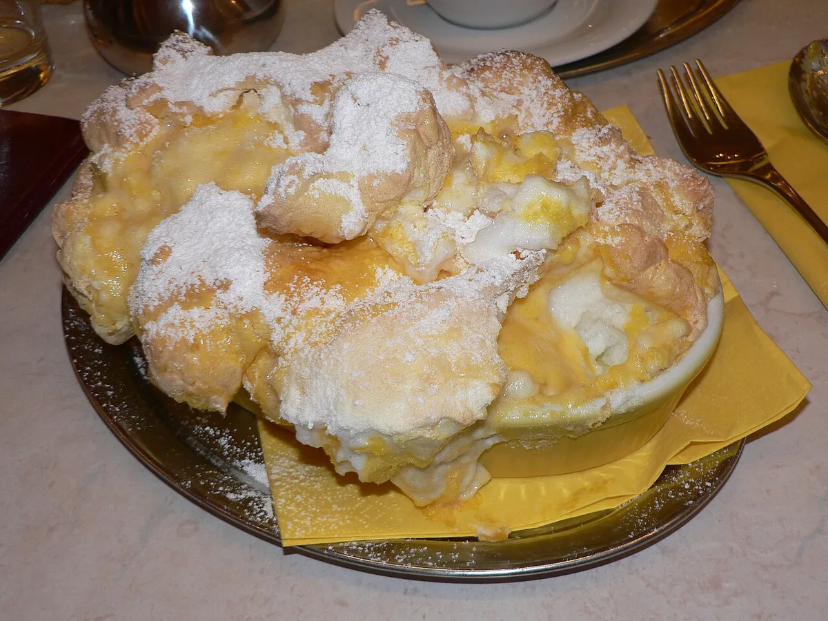 A three-peaked Salzburger Nockerl soufflé dusted with powdered sugar on a Salzburg restaurant table — 1