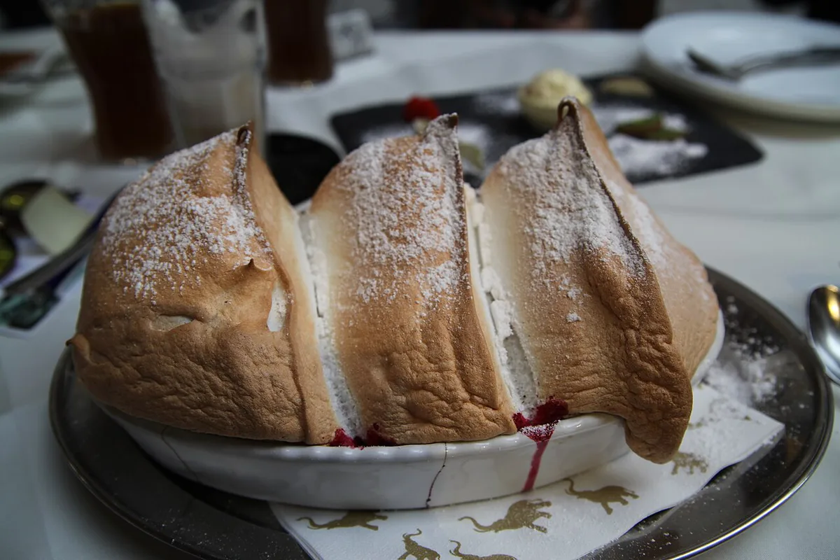 A three-peaked Salzburger Nockerl soufflé dusted with powdered sugar on a Salzburg restaurant table — 2