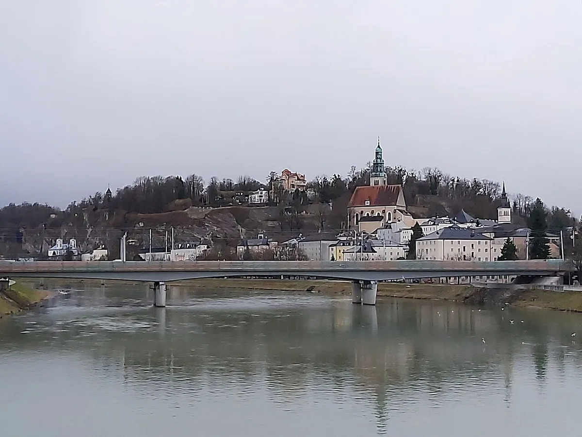 View across the Salzach River toward Salzburg's old town and Mönchsberg hill — 1